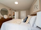 Thumbnail 43 of 50 - A bedroom with a large bed and a mirror on the dresser.