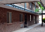 Thumbnail 5 of 8 - a brick building with a balcony and a chair