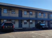 Thumbnail 6 of 8 - a motel building with cars parked in front of it