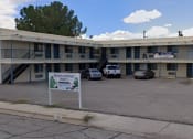 Thumbnail 2 of 8 - a motel with a sign in front of a parking lot