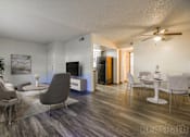Thumbnail 1 of 13 - A living room with a grey sofa and a wooden floor.