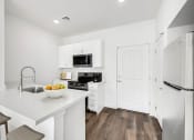 Thumbnail 4 of 17 - a kitchen with white cabinets and a white counter top