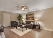 Thumbnail 7 of 19 - an empty living room with couches and a ceiling fan