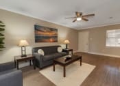 Thumbnail 8 of 19 - a living room with a couch and a ceiling fan