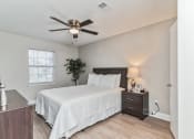 Thumbnail 12 of 19 - a bedroom with a large bed and a ceiling fan