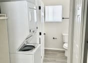 Thumbnail 6 of 11 - a small bathroom with a washer and dryer in it
