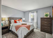 Thumbnail 6 of 23 - a bedroom with a bed and a dresser