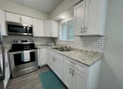 Thumbnail 4 of 22 - a kitchen with white cabinets and stainless steel appliances