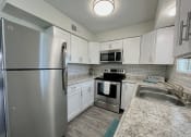 Thumbnail 5 of 22 - a kitchen with stainless steel appliances and granite counter tops