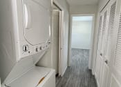 Thumbnail 6 of 22 - a laundry room with a washer and dryer and a hallway with a closet