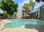 Thumbnail 13 of 22 - a swimming pool with a yellow umbrella in front of a building