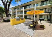 Thumbnail 15 of 22 - a patio with a yellow table and chairs and a barbecue grill