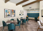 Thumbnail 19 of 22 - a dining area with tables and chairs and paintings on the wall
