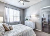Thumbnail 22 of 37 - a bedroom with a bed and a ceiling fan at Republic at Alamo Heights, San Antonio Texas