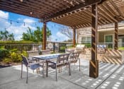 Thumbnail 5 of 37 - a patio with a table and chairs and a grill at Republic at Alamo Heights, Texas