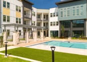 Thumbnail 63 of 65 - an exterior view of an apartment building with a swimming pool at Birdie on Woodland Greens, Austin