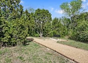 Thumbnail 61 of 72 - a park with a bench and a dirt path at Radius on Grove, Texas