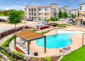 Thumbnail 13 of 72 - a swimming pool in front of an apartment building at Radius on Grove, Austin, 78741