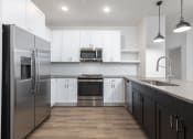 Thumbnail 42 of 65 - a kitchen with white cabinets and stainless steel appliances at Birdie on Woodland Greens, Austin, Texas