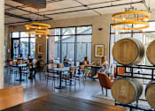 Thumbnail 10 of 30 - Tasting room with wine barrels and seating at THE'68 Apartments, San Antonio, Texas