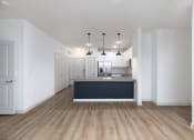 Thumbnail 43 of 65 - a kitchen and living room with white walls and wood floors at Birdie on Woodland Greens, Texas