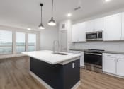 Thumbnail 41 of 65 - a white and black kitchen with white cabinets and stainless steel appliances at Birdie on Woodland Greens, Austin