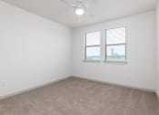 Thumbnail 32 of 65 - an empty room with two windows and a ceiling fan at Birdie on Woodland Greens, Austin, 78726