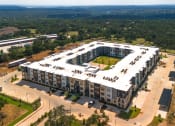 Thumbnail 60 of 65 - an aerial view of an apartment complex with a parking lot and trees at Birdie on Woodland Greens, Austin, TX
