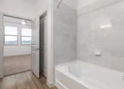 Thumbnail 36 of 65 - a bathroom with a tub and a shower and a door at Birdie on Woodland Greens, Austin, Texas