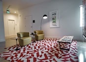 Thumbnail 11 of 30 - Lounge seating area with geometric patterned rug at THE'68 Apartments, San Antonio, Texas