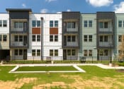 Thumbnail 59 of 65 - an exterior view of an apartment building with green grass at Birdie on Woodland Greens, Austin, TX