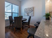 Thumbnail 23 of 41 - A dining room with a table set for four.