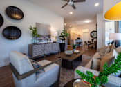 Thumbnail 17 of 41 - A living room with a grey sofa, a wooden coffee table, and a ceiling fan.