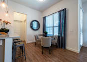 Thumbnail 28 of 41 - A dining room with a table and chairs.