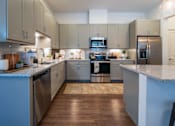 Thumbnail 27 of 41 - A modern kitchen with wooden floors and stainless steel appliances.
