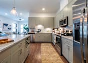Thumbnail 25 of 41 - A modern kitchen with stainless steel appliances and wooden flooring.