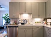 Thumbnail 39 of 41 - A kitchen with a stainless steel dishwasher and grey cabinets.