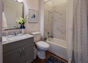 Thumbnail 34 of 41 - A bathroom with a toilet, sink, and bathtub.