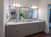 Thumbnail 38 of 41 - A bathroom with a double sink vanity and a large mirror above it.
