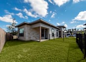 Thumbnail 21 of 41 - A modern house with a stone exterior and a black fence.