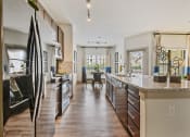 Thumbnail 50 of 59 - a kitchen with stainless steel appliances and a large island with granite countertops at Alvista Round Rock, Round Rock, Texas