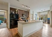 Thumbnail 51 of 59 - a kitchen and living room with a large island with granite countertops at Alvista Round Rock, Round Rock, 78664