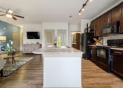 Thumbnail 59 of 59 - a kitchen and living room with wood floors and a ceiling fan at Alvista Round Rock, Round Rock, TX, 78664