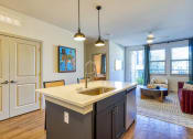 Thumbnail 21 of 65 - a kitchen with an island and a living room with a couch at Birdie on Woodland Greens, Texas 78726