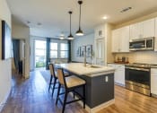 Thumbnail 20 of 65 - an open kitchen with a large island with chairs and a counter at Birdie on Woodland Greens, Austin