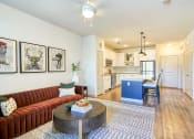 Thumbnail 23 of 65 - a living room with a couch and a table in front of a kitchen at Birdie on Woodland Greens, Texas