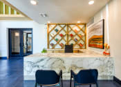 Thumbnail 11 of 65 - a lobby with a marble counter and blue chairs at Birdie on Woodland Greens, Texas