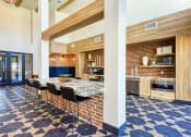Thumbnail 10 of 65 - a large kitchen with a long table and chairs in a lobbyat Birdie on Woodland Greens, Austin