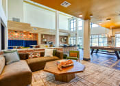 Thumbnail 6 of 65 - a clubhouse with couches and a table with a poolat Birdie on Woodland Greens, Austin, Texas