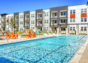 Thumbnail 8 of 65 - A swimming pool in front of apartment buildings.